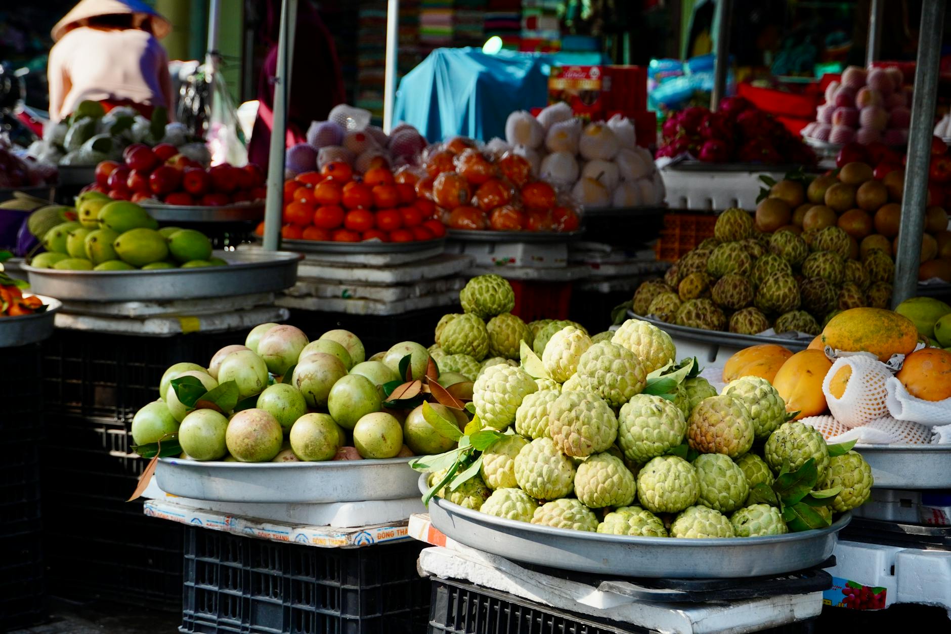 Colorful market stall with diverse fresh fruits on display in tropical setting.